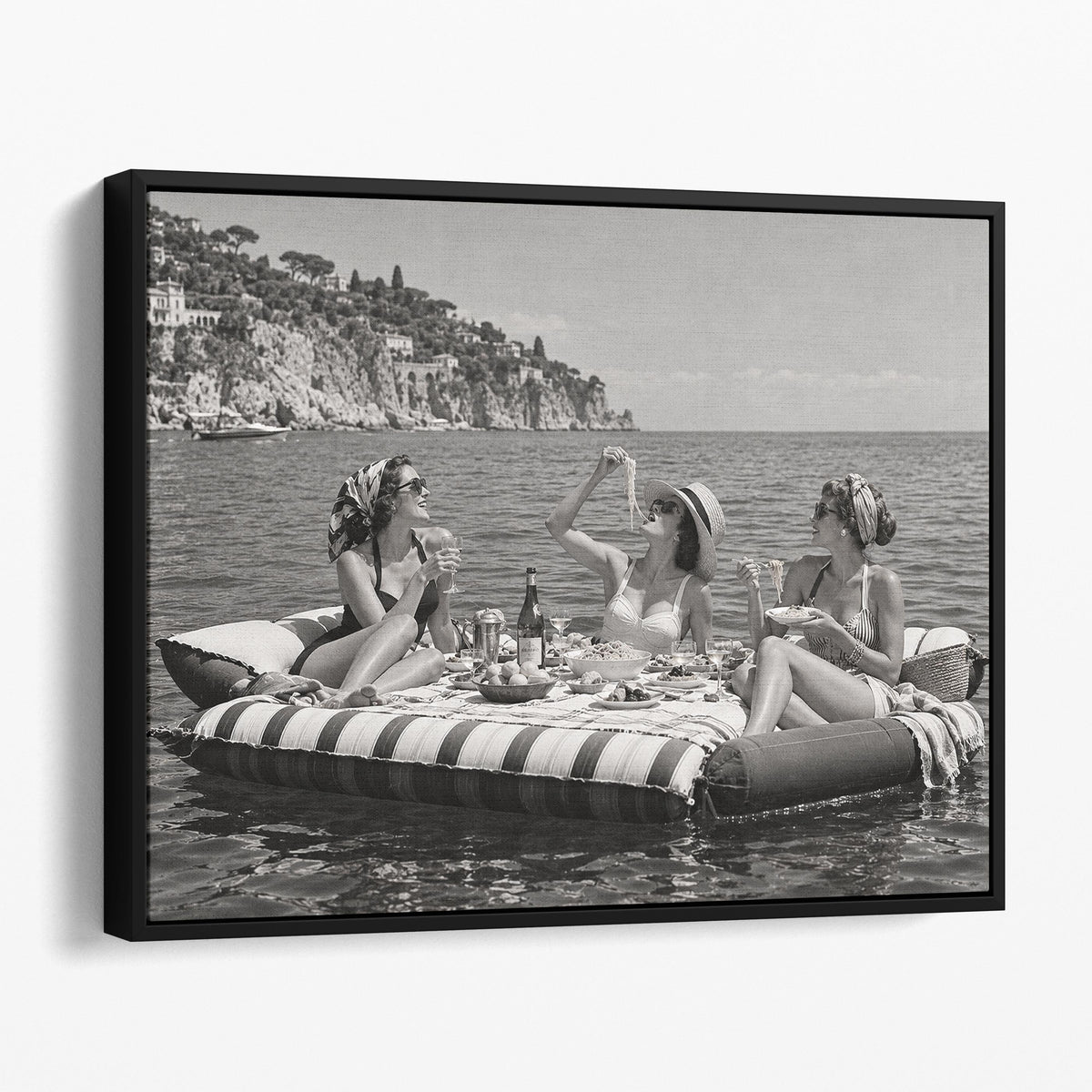 Floating Luncheon, three young women eat spaghetti on inflatable mattresses