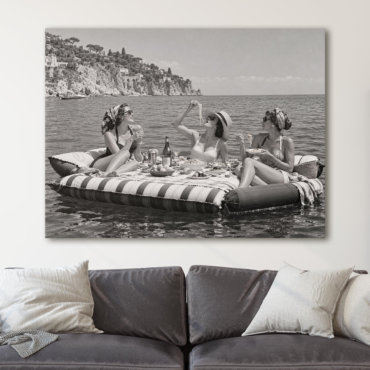 Floating Luncheon, three young women eat spaghetti on inflatable mattresses